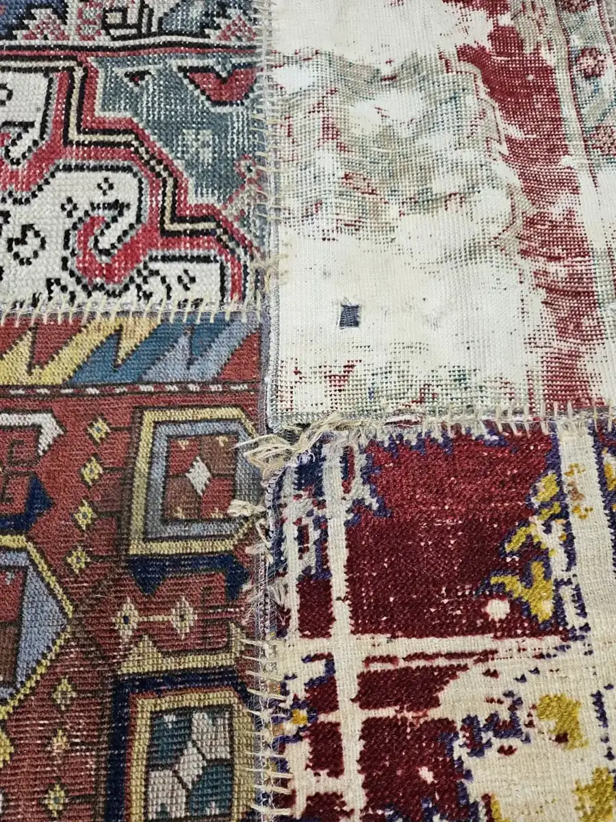 Close detail of an antique patchwork rug&rsquo;s stitched panels after cleaning