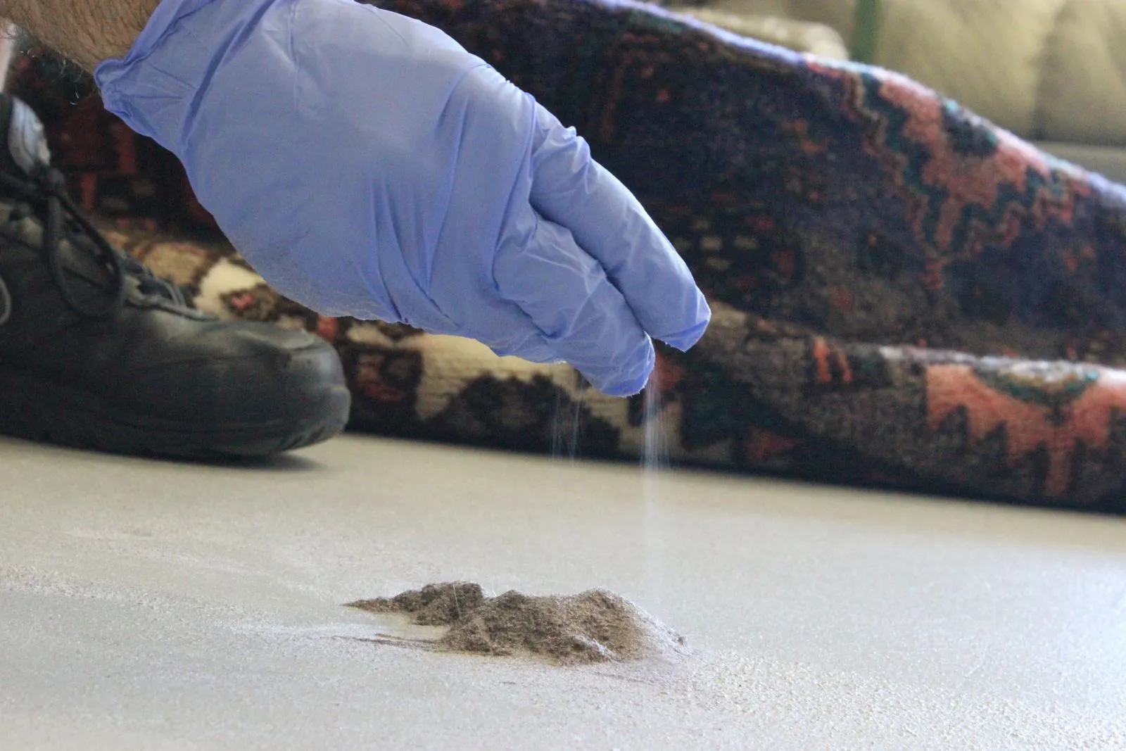 Piles of dry soil beaten out of a rug during the dusting stage