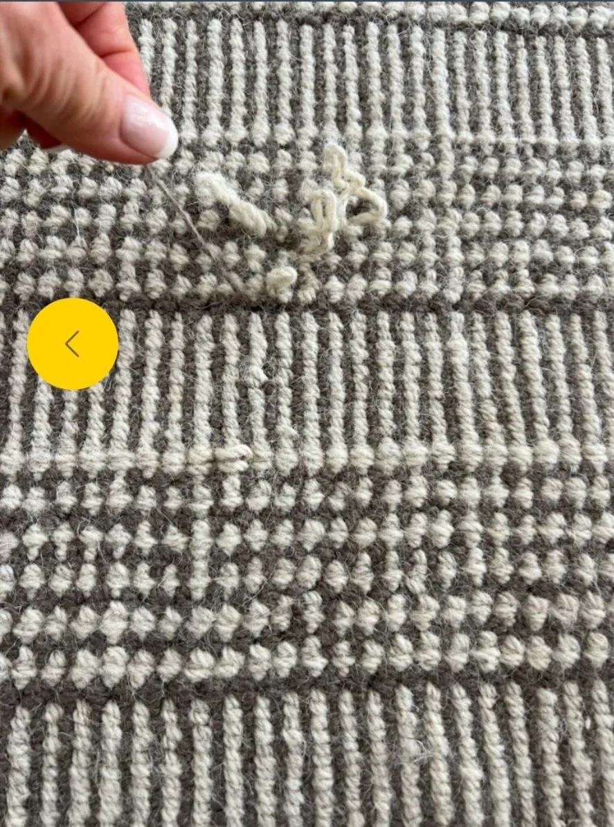 Hands looping yarn to rebuild a flatweave rug at the bench